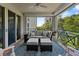 Inviting outdoor balcony with a comfortable couch, ottomans, rug, and a serene view of lush greenery at 4750 Dolphin Cay S Ln # 209, St Petersburg, FL 33711