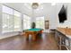 Bright game room featuring a pool table, wood floors, a large screen TV, and lots of natural light at 4750 Dolphin Cay S Ln # 209, St Petersburg, FL 33711