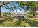 Scenic view of a peaceful lake from a shaded park bench, offering a tranquil setting with mature trees at 4750 Dolphin Cay S Ln # 209, St Petersburg, FL 33711