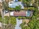Aerial view of home showcasing a pool, enclosed patio, lush landscaping, and surrounding properties at 515 Orange St, Palm Harbor, FL 34683