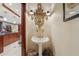Charming powder room with pedestal sink, decorative mirror and elegant lighting at 515 Orange St, Palm Harbor, FL 34683