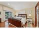 Bright bedroom featuring hardwood floors, a cozy bed, and access to a private balcony at 515 Orange St, Palm Harbor, FL 34683