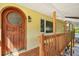 Inviting front entrance featuring a beautiful wood door, wooden railing, and stairs at 515 Orange St, Palm Harbor, FL 34683