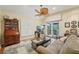 Comfortable living room with sofa, entertainment center, plantation shutters and access to balcony at 515 Orange St, Palm Harbor, FL 34683