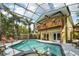 A stunning screened-in pool and patio with a balcony and outdoor dining area at 515 Orange St, Palm Harbor, FL 34683