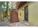 An exterior staircase leading to a private entrance, surrounded by lush landscaping at 515 Orange St, Palm Harbor, FL 34683