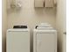 Bright laundry room features a washer, dryer, and shelving for storage at 5618 Red Kite Dr, Wimauma, FL 33598