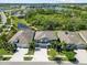 Aerial view of three beautiful homes with well-maintained lawns and landscaping in a desirable neighborhood with a pond at 5809 Alabaster Stone Ln, Apollo Beach, FL 33572