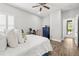 Bright bedroom featuring a ceiling fan, wood-look tile floors, and a cozy workspace at 5809 Alabaster Stone Ln, Apollo Beach, FL 33572