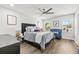 Bedroom featuring ceiling fan, wall art, and bed with decorative pillows and stylish couch at 5809 Alabaster Stone Ln, Apollo Beach, FL 33572