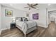 Comfortable bedroom with ceiling fan, dark hardwood floors, and serene window view at 5809 Alabaster Stone Ln, Apollo Beach, FL 33572
