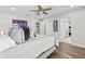 Bright bedroom featuring a ceiling fan, hardwood floors, and natural light at 5809 Alabaster Stone Ln, Apollo Beach, FL 33572