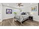 Bright bedroom with hardwood floors, ceiling fan, and serene window view at 5809 Alabaster Stone Ln, Apollo Beach, FL 33572