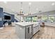 Bright kitchen with an island, farm sink, stainless appliances, and an open floor plan at 5809 Alabaster Stone Ln, Apollo Beach, FL 33572