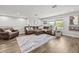 Spacious living room with cozy seating, wood floors, and natural light at 5809 Alabaster Stone Ln, Apollo Beach, FL 33572