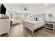 Spacious main bedroom with hardwood floors, decorative ceiling fan, and large windows bringing in plenty of natural light at 5809 Alabaster Stone Ln, Apollo Beach, FL 33572