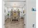 Bright home office features a chandelier, wood-look tile flooring, and custom built-in shelving at 5809 Alabaster Stone Ln, Apollo Beach, FL 33572