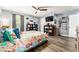 A cozy bedroom with light walls, ceiling fan, hardwood floors, and well decorated shelves at 626 Diamond Ridge Rd, Seffner, FL 33584