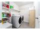 Bright laundry room featuring a modern washer and dryer, storage shelves, and tiled flooring at 626 Diamond Ridge Rd, Seffner, FL 33584
