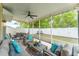 Relaxing screened patio with comfortable seating, ceiling fan, and backyard view with white fence at 626 Diamond Ridge Rd, Seffner, FL 33584