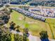 Aerial view showcasing a neighborhood adjacent to a golf course, with a commercial area visible at 6426 Bradford Woods Dr, Zephyrhills, FL 33542