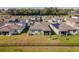 Aerial view of the home showing the backyard and the surrounding neighborhood with solar panels at 6426 Bradford Woods Dr, Zephyrhills, FL 33542