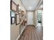 Hallway with wood floors, decorated with a gallery wall of framed photos and diplomas at 6426 Bradford Woods Dr, Zephyrhills, FL 33542