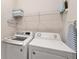 Well-equipped laundry room with modern washer, dryer, and shelving at 6426 Bradford Woods Dr, Zephyrhills, FL 33542