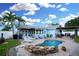 This backyard oasis features a pool, palm trees, a deck, and outdoor seating at 6513 14Th W Ave, Bradenton, FL 34209