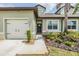 Well-maintained townhome showcasing a neat lawn, a two-car garage, and pleasant landscaping leading to the front door at 6748 Ripple Pond Loop, Zephyrhills, FL 33541