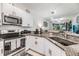 Well-equipped kitchen featuring stainless steel appliances and granite countertops, open to the living space at 6748 Ripple Pond Loop, Zephyrhills, FL 33541