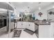 Bright kitchen with stainless steel appliances and granite counters, seamlessly connecting to the living area at 6748 Ripple Pond Loop, Zephyrhills, FL 33541