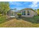 A serene backyard featuring a screened pool, lush lawn, and mature landscaping, creating a private outdoor oasis at 7051 Derwent Glen Cir, Land O Lakes, FL 34637