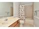 Bathroom with a vanity, a full tub and shower with decorative curtain, tile flooring, and neutral paint at 7051 Derwent Glen Cir, Land O Lakes, FL 34637