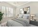 Cozy bedroom filled with natural light featuring plantation shutters, soft bedding, and tasteful decor at 7051 Derwent Glen Cir, Land O Lakes, FL 34637