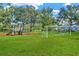 Community park featuring a playground and soccer field on a green lawn surrounded by mature trees at 7051 Derwent Glen Cir, Land O Lakes, FL 34637