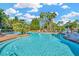 Large community pool surrounded by palm trees, offering ample seating and relaxation areas under sunny skies at 7051 Derwent Glen Cir, Land O Lakes, FL 34637