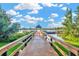 Scenic view of a wooden dock extending into a tranquil lake with a charming gazebo and blue skies at 7051 Derwent Glen Cir, Land O Lakes, FL 34637