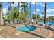Cozy community hot tub with nearby lounge chairs set amongst a patio and lush palm tree backdrop at 7051 Derwent Glen Cir, Land O Lakes, FL 34637