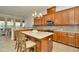 Spacious kitchen features granite countertops, wooden cabinets, and a stylish center island with barstool seating at 7051 Derwent Glen Cir, Land O Lakes, FL 34637