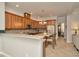 Open-concept kitchen boasts granite counters, stainless steel appliances, wooden cabinetry, and seamless flow to adjacent living areas at 7051 Derwent Glen Cir, Land O Lakes, FL 34637