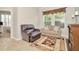 Living room featuring tile flooring, a reclining chair, sofa, and decorative area rug at 7051 Derwent Glen Cir, Land O Lakes, FL 34637