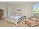 Comfortable main bedroom with a chaise lounge, neutral walls, large windows, and a rustic wood bedframe at 7051 Derwent Glen Cir, Land O Lakes, FL 34637