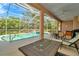 A poolside patio has dining and lounging furniture, perfect for entertaining next to the screened-in pool at 7051 Derwent Glen Cir, Land O Lakes, FL 34637