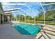 A screened-in pool with clear water, surrounded by a patio and lush greenery, offers a private outdoor retreat at 7051 Derwent Glen Cir, Land O Lakes, FL 34637