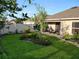 Serene backyard with green grass, an island of trees, and a covered patio perfect for outdoor relaxation at 7737 Sail Clover Ln, Zephyrhills, FL 33540
