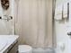 Bright bathroom featuring a modern vanity, neutral shower curtain, and decorative wall art at 7737 Sail Clover Ln, Zephyrhills, FL 33540