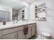 Bathroom featuring dual sinks, vanity with storage, and a decorative mirror with inspirational quote at 7737 Sail Clover Ln, Zephyrhills, FL 33540