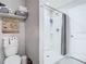Bathroom featuring a toilet, and walk-in shower and shelving for storage at 7737 Sail Clover Ln, Zephyrhills, FL 33540