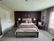 Comfortable carpeted bedroom features stylish accent wall, soft natural lighting, and modern furnishings at 7737 Sail Clover Ln, Zephyrhills, FL 33540